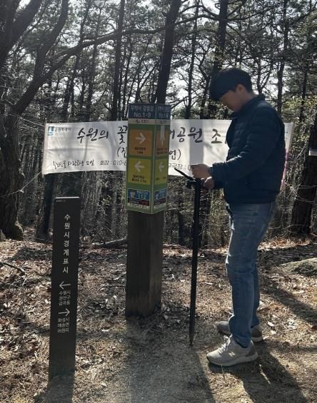 수원시 관계자가 GNSS를 활용해 칠보산 인근에 설치된 안내시설물의 위치정보를 측정하고 있다